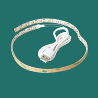 LED plant grow light with USB cable on a green background.