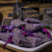 Sachets of dried lavender buds on a white plate with 'Lavender Sachets' sign in the background at House of Agave.