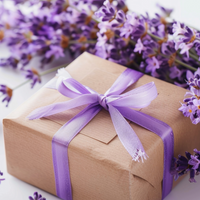 Gift box of premium lavender body care products with a purple ribbon surrounded by lavender flowers on a light background by House of Agave.