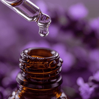 Bottle of premium lavender essential oil with a dropper over lavender flowers in the background.