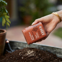 Small orange box of organic plant food called Soil and Root Boost, sold by House of Agave.
