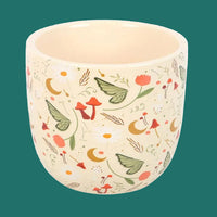 Ceramic planter with nature-themed design on a white background