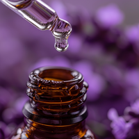 Bottle of premium lavender essential oil with a dropper over lavender flowers in the background.