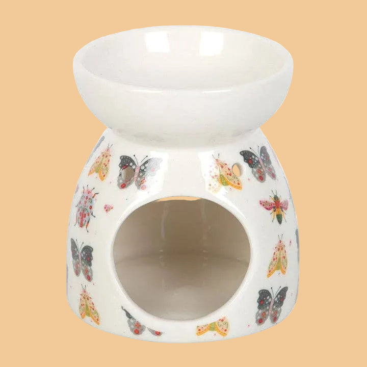Ceramic oil burner with butterfly designs on a white background