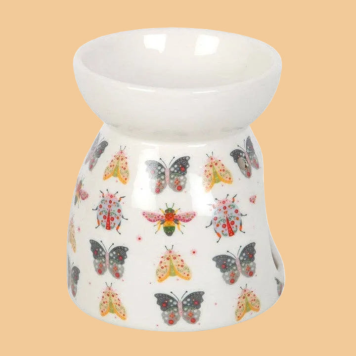 White ceramic oil burner with colorful butterfly design on a white background
