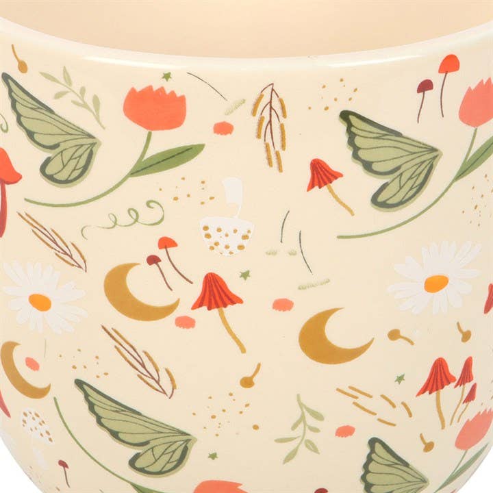 Patterned ceramic planter with flowers, leaves, and mushrooms on a beige background.