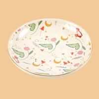 Decorative ceramic plate with floral and leaf patterns on a white background