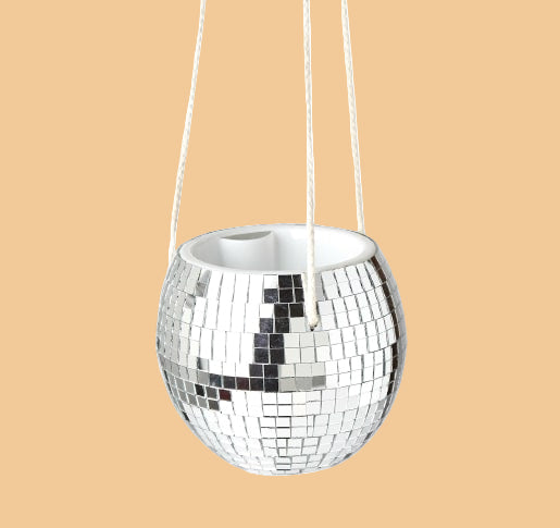 Silver disco ball hanging planter for trailing houseplants against a plain background.
