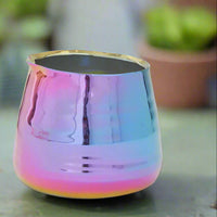 Multicolored metallic planter for compact houseplants on a blurred background.
